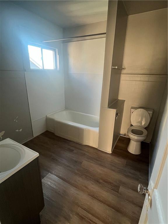 full bathroom featuring shower / bathing tub combination, hardwood / wood-style floors, vanity, and toilet