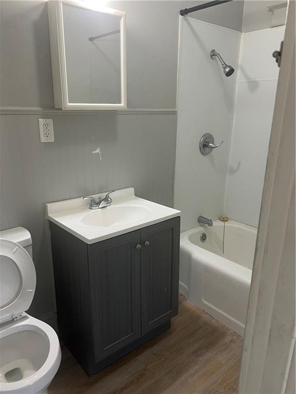 full bathroom with shower / tub combination, vanity, hardwood / wood-style flooring, and toilet