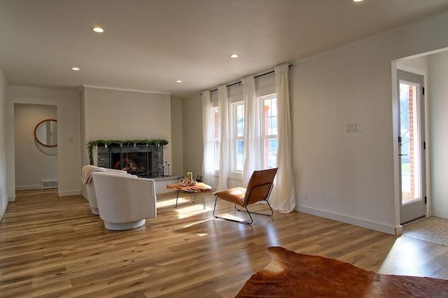 living room with crown molding and light wood-type flooring