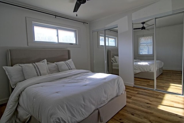 bedroom with multiple windows, ceiling fan, and hardwood / wood-style floors