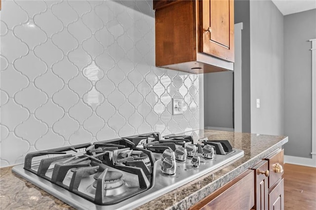 kitchen with wood-type flooring, tasteful backsplash, and stainless steel gas cooktop