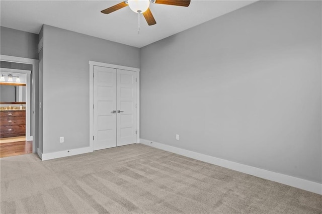 unfurnished bedroom featuring ceiling fan, light colored carpet, and a closet