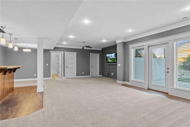 basement featuring light carpet, ceiling fan, and ornamental molding