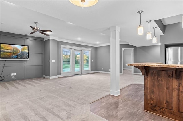 unfurnished living room featuring carpet, french doors, ceiling fan, and crown molding