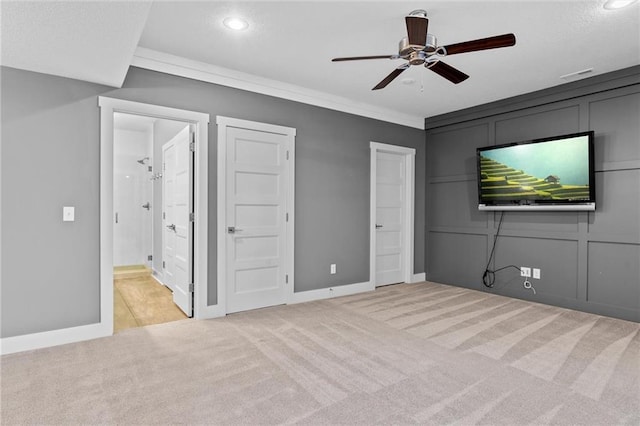 unfurnished bedroom with ensuite bathroom, ceiling fan, light colored carpet, and crown molding