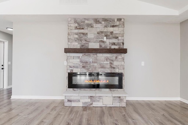 room details with a fireplace, wood finished floors, and baseboards