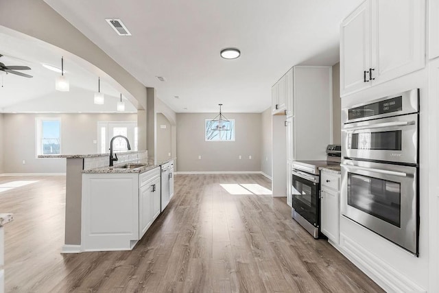 kitchen with stainless steel appliances, a wealth of natural light, visible vents, and a sink