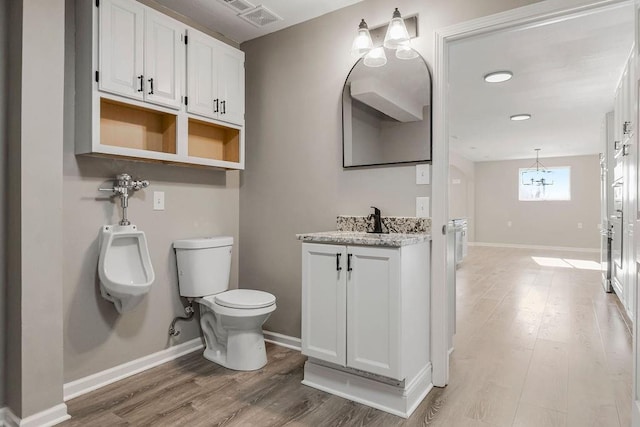 bathroom with toilet, baseboards, and wood finished floors