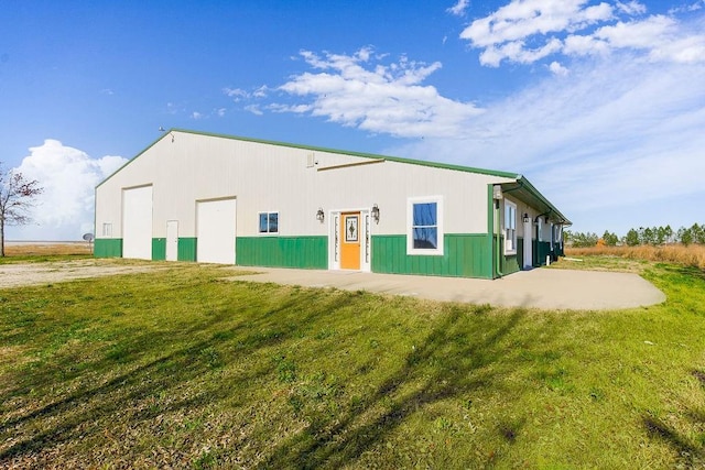 back of house with a garage and a yard