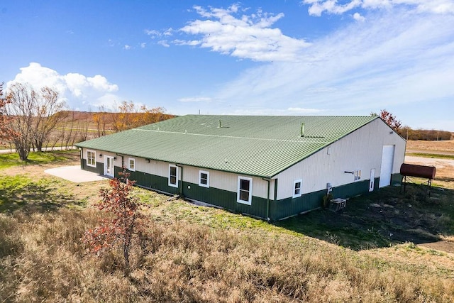 view of side of home featuring metal roof and cooling unit