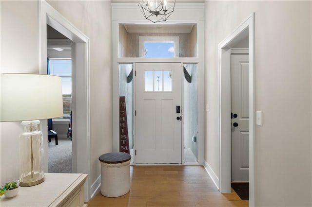 entryway featuring a chandelier, light hardwood / wood-style flooring, and ornamental molding