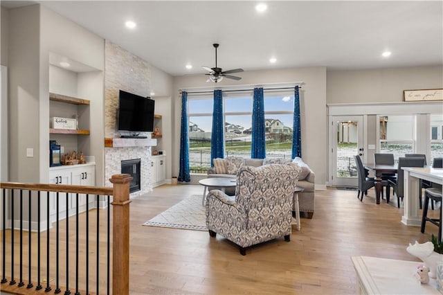 living room with a fireplace, light hardwood / wood-style floors, and a healthy amount of sunlight