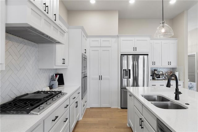 kitchen featuring white cabinets, pendant lighting, sink, and appliances with stainless steel finishes