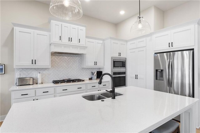 kitchen featuring pendant lighting, white cabinetry, sink, and stainless steel appliances