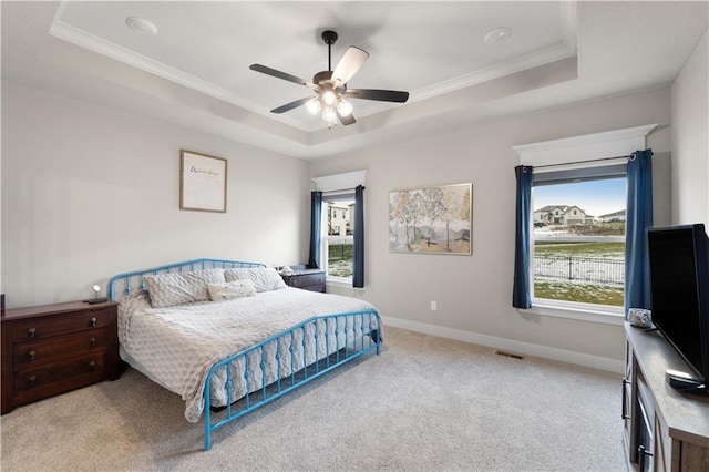 carpeted bedroom featuring a raised ceiling, ceiling fan, and ornamental molding