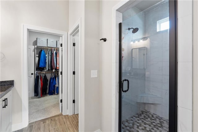 bathroom with hardwood / wood-style floors, vanity, and walk in shower