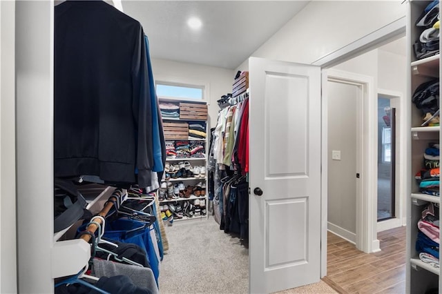 walk in closet with light hardwood / wood-style flooring