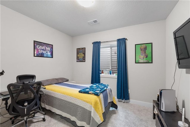 bedroom with carpet floors and a textured ceiling