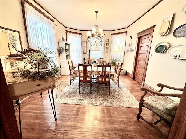 dining room featuring hardwood / wood-style flooring, crown molding, and a notable chandelier