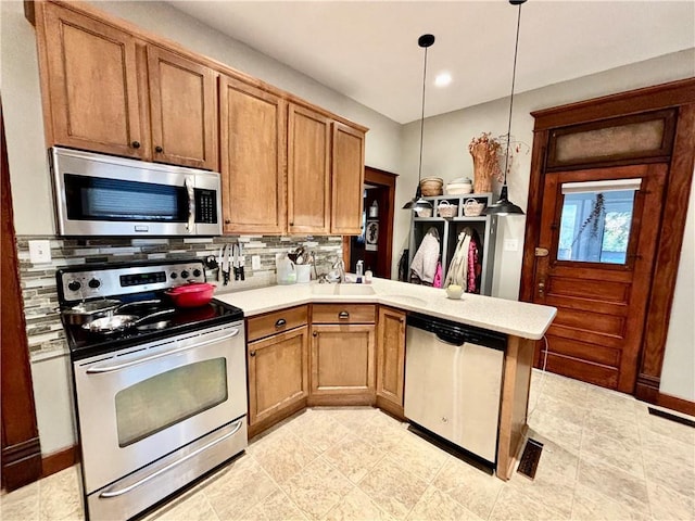 kitchen with decorative light fixtures, sink, decorative backsplash, kitchen peninsula, and stainless steel appliances