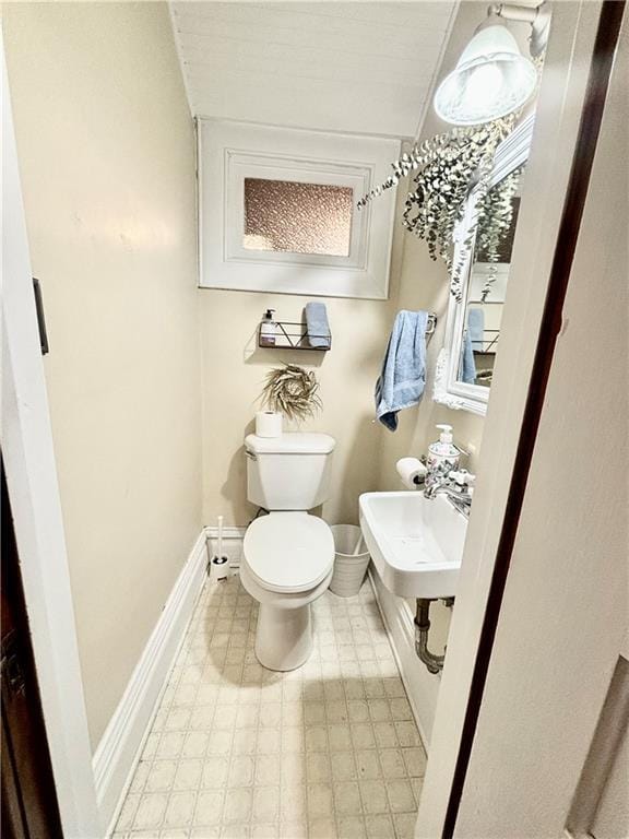 bathroom with lofted ceiling and toilet