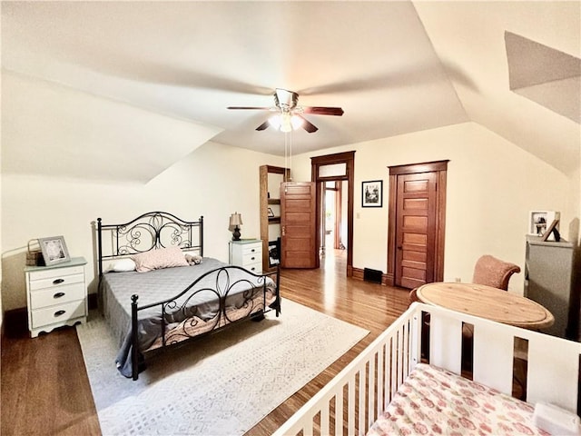 bedroom with ceiling fan, vaulted ceiling, and hardwood / wood-style floors