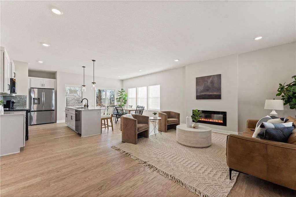 living room featuring sink and light wood-type flooring