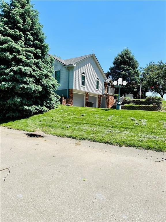 view of side of home featuring a yard and a garage