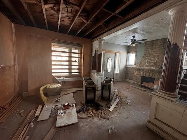 misc room featuring ornate columns, ceiling fan, and a healthy amount of sunlight