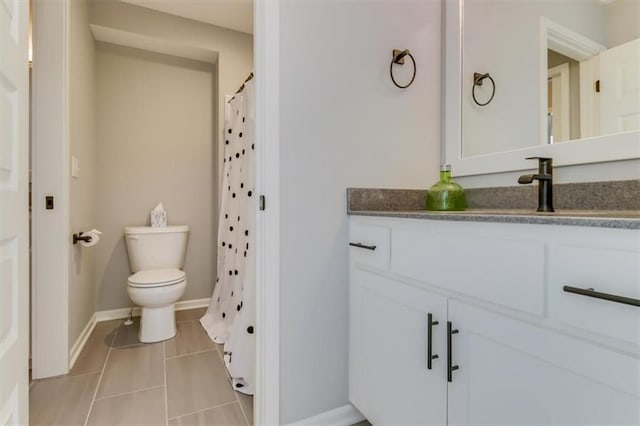 bathroom featuring vanity, tile patterned flooring, and toilet