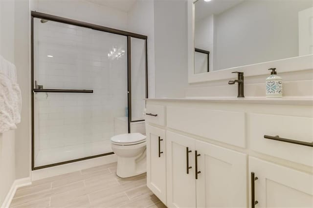 bathroom featuring vanity, toilet, and walk in shower