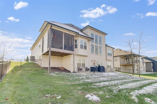 rear view of house with a yard and a sunroom