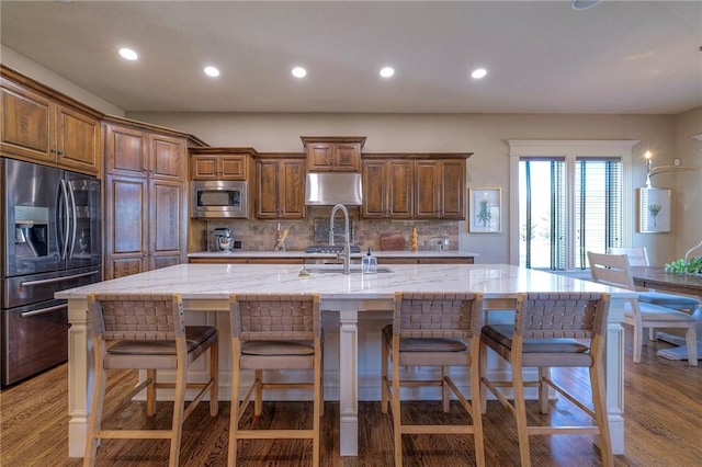 kitchen featuring a kitchen breakfast bar, a spacious island, appliances with stainless steel finishes, and tasteful backsplash