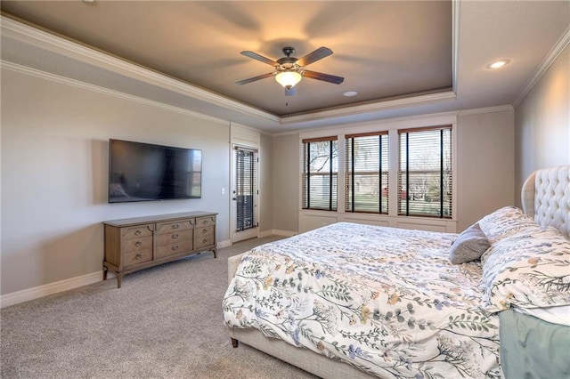 bedroom featuring a tray ceiling, ceiling fan, light carpet, and ornamental molding