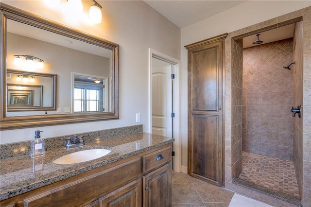 bathroom featuring tile patterned floors, vanity, and tiled shower