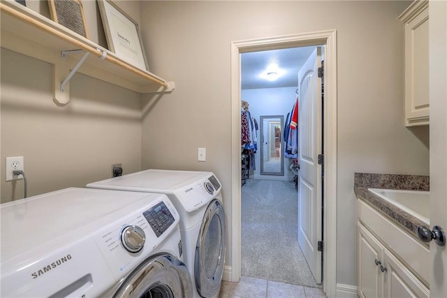 clothes washing area with washing machine and clothes dryer, cabinets, and light colored carpet