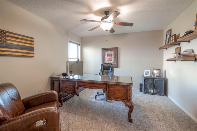 home office featuring carpet flooring, ceiling fan, and a textured ceiling