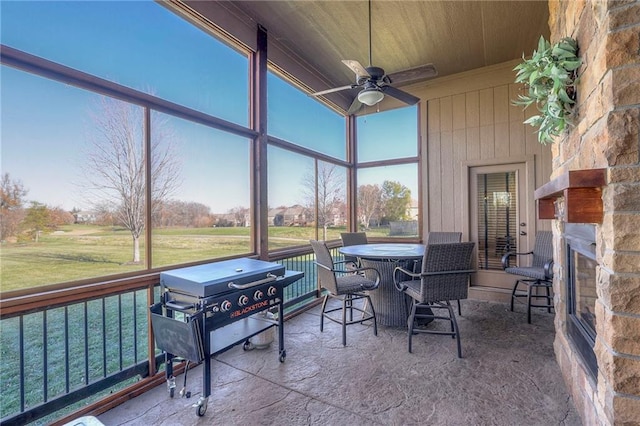 sunroom featuring ceiling fan, a healthy amount of sunlight, and wooden ceiling