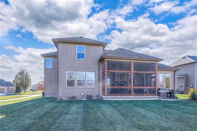 back of property with a yard and a sunroom