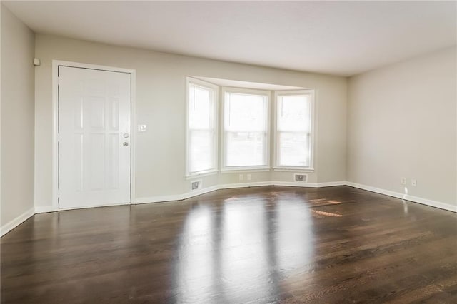 unfurnished room with dark hardwood / wood-style flooring