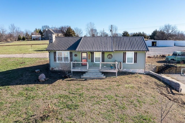 ranch-style house featuring covered porch and a front yard