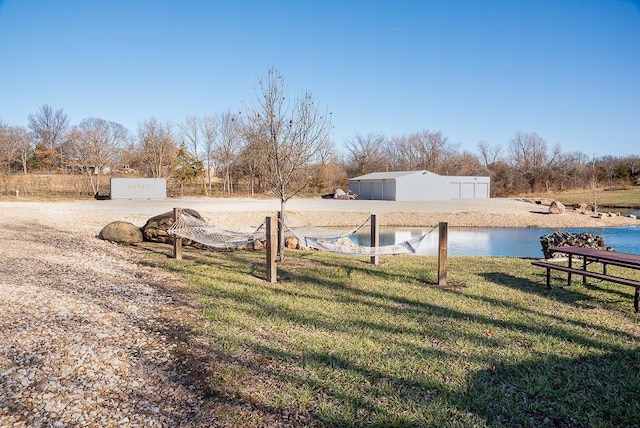 view of yard featuring a water view and an outbuilding