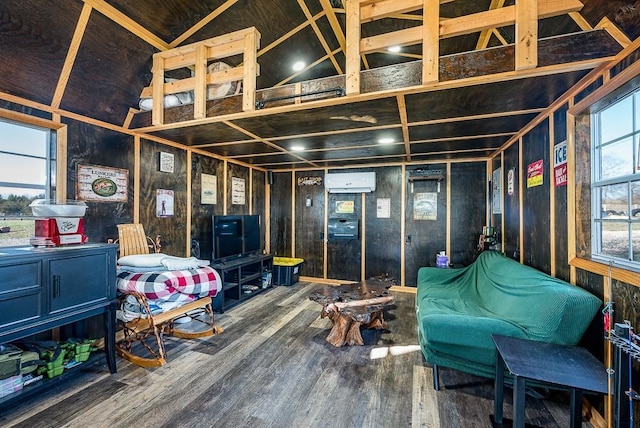 playroom with a wall mounted air conditioner, wood-type flooring, and high vaulted ceiling