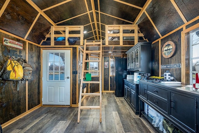 kitchen with black refrigerator, dark hardwood / wood-style flooring, and vaulted ceiling