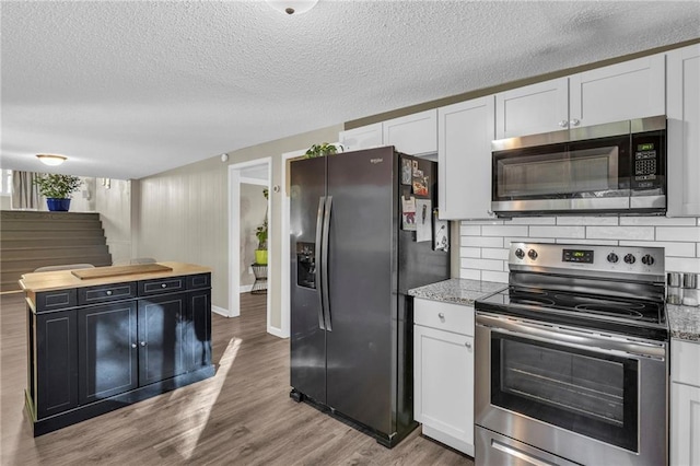 kitchen featuring white cabinetry, hardwood / wood-style floors, and appliances with stainless steel finishes