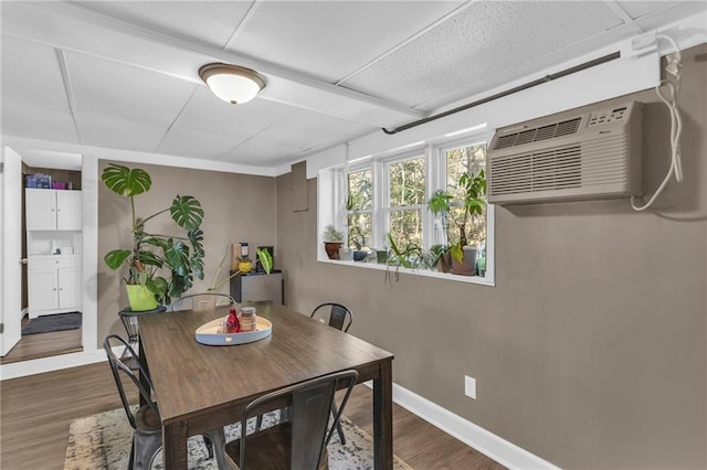 dining space with hardwood / wood-style floors and a wall mounted air conditioner