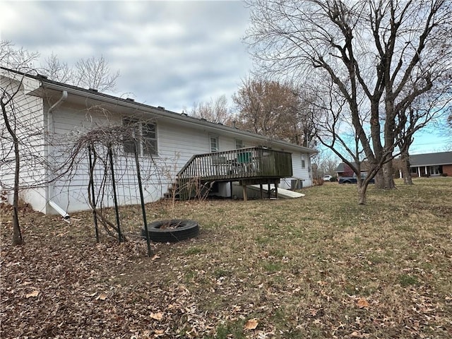 view of yard with a deck and an outdoor fire pit