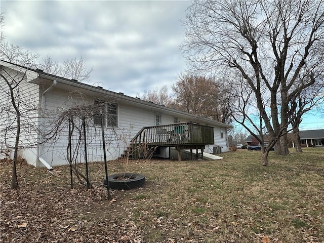 rear view of property with a lawn and a deck