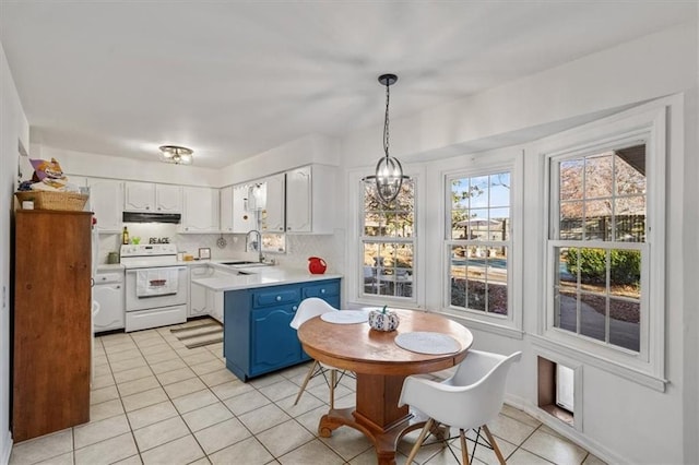 kitchen featuring blue cabinetry, light countertops, white electric range, a sink, and under cabinet range hood