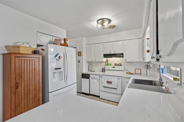 kitchen featuring under cabinet range hood, white appliances, white cabinetry, light countertops, and backsplash